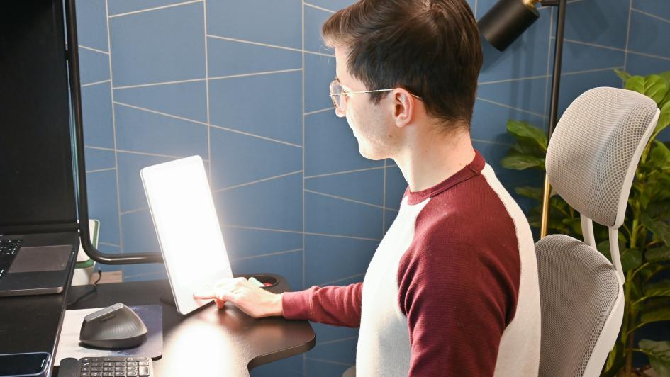 person sitting at desk with light therapy lamp